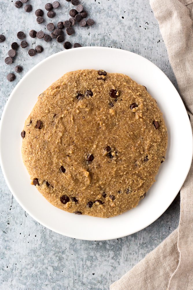 Almond Flour Chocolate Chip Cookie served on plate with chocolate chips scattered