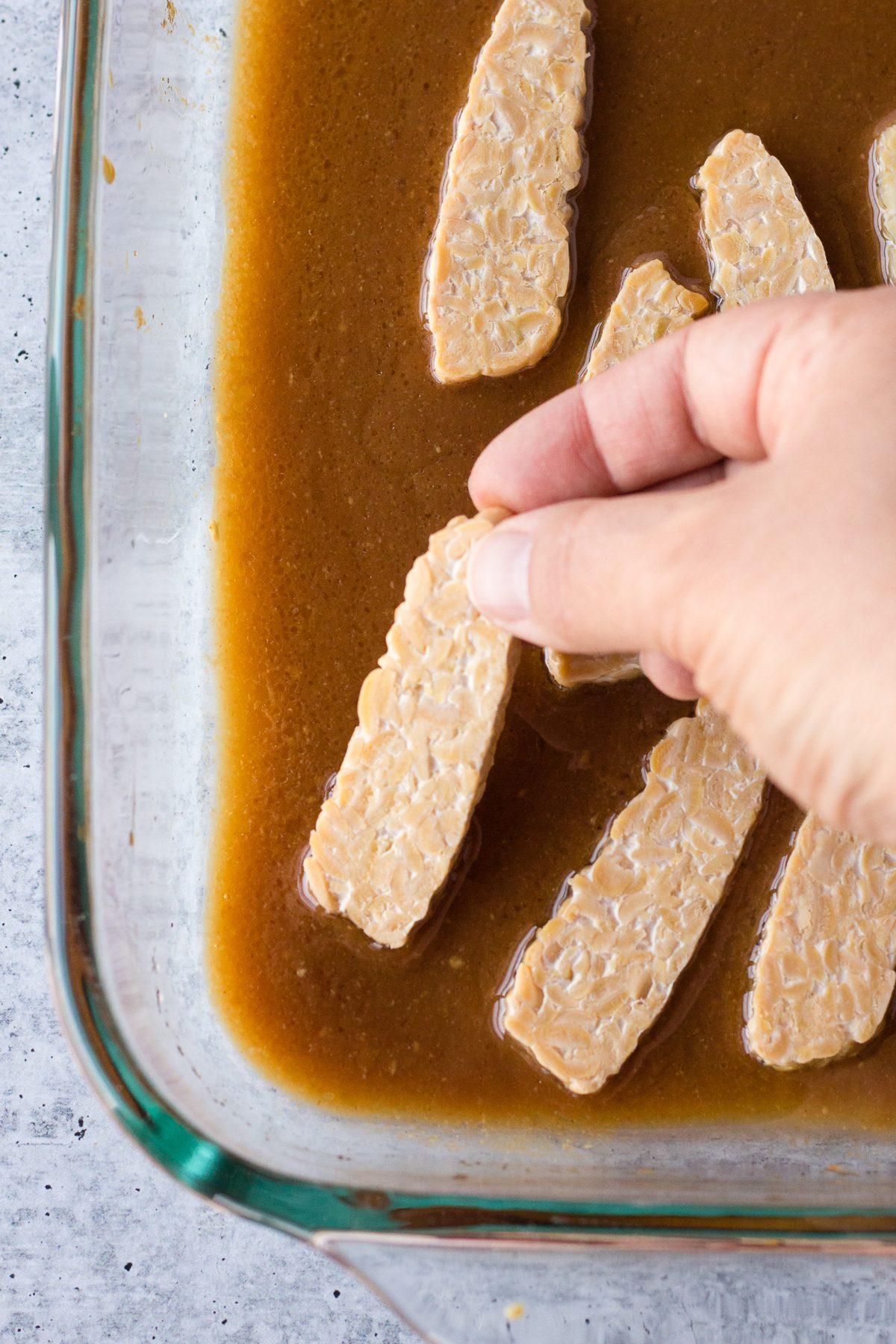 Adding tempeh to marinade by Flora & Vino