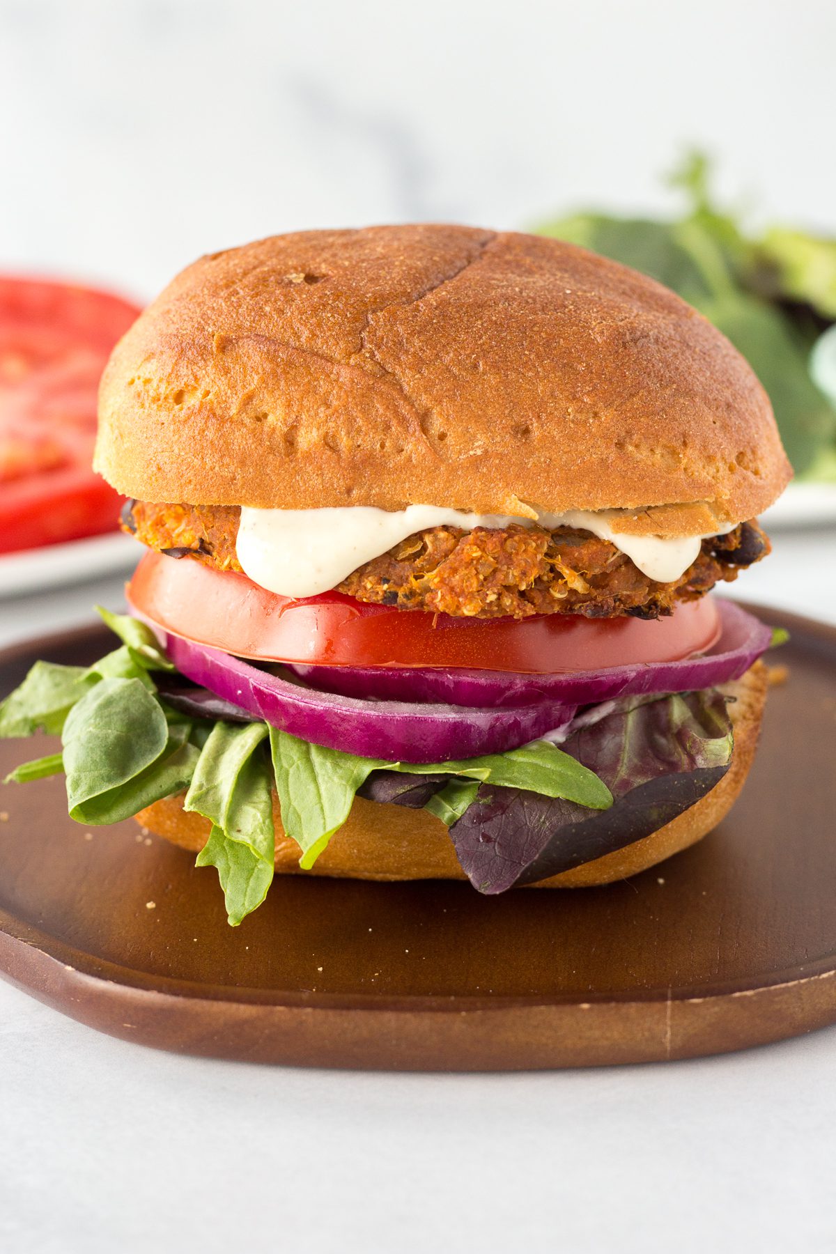 Sweet Potato Black Bean Burgers served on plate with tomato and lettuce in the background