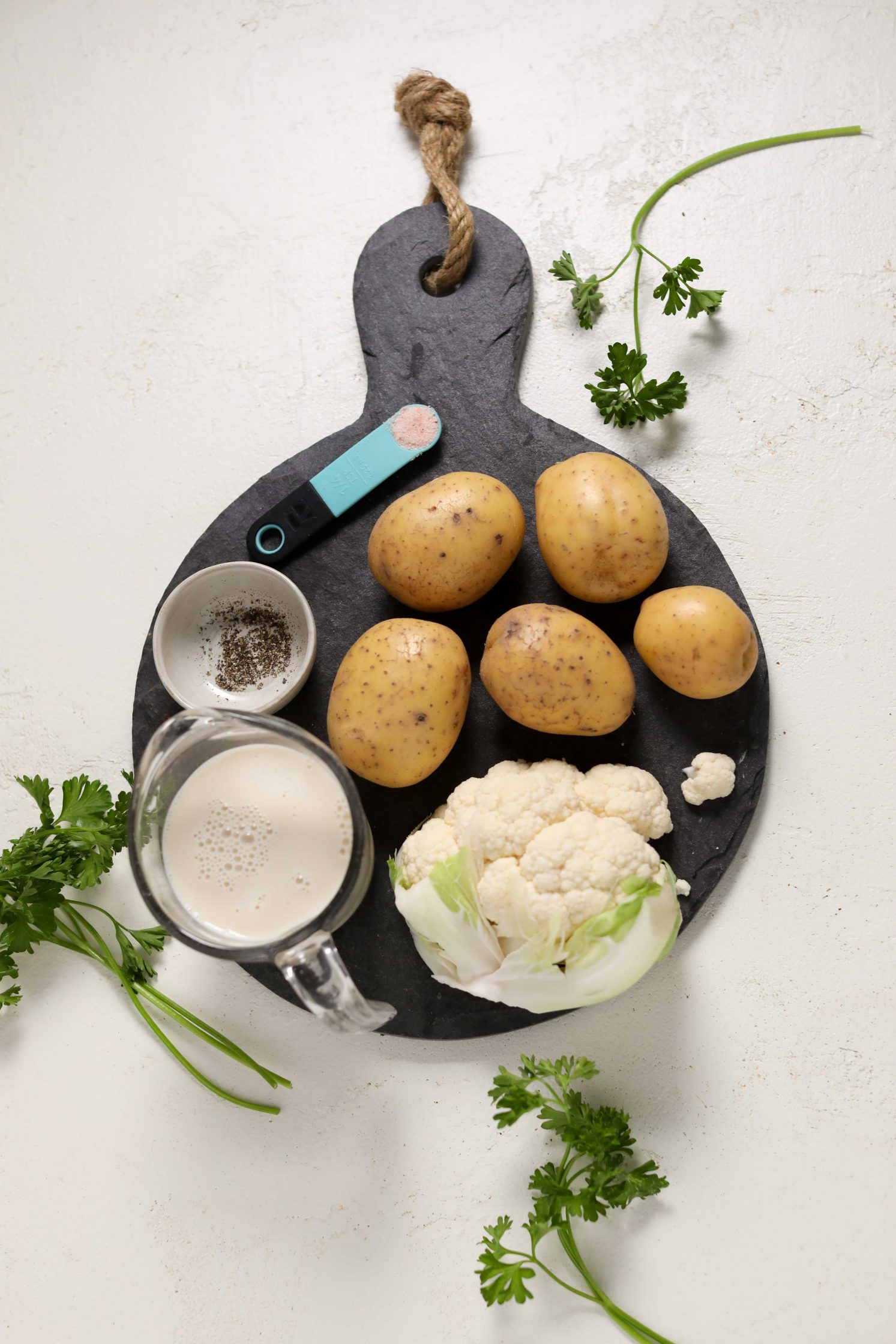 Cauliflower, yukon potatoes, salt, pepper, and almond milk on board by Flora & Vino