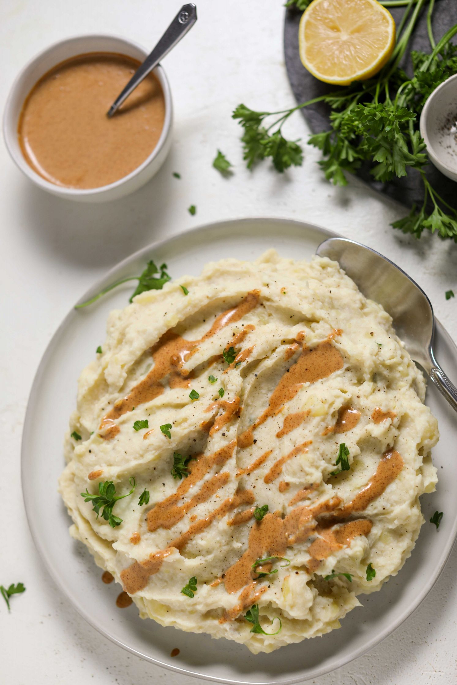 Cauliflower Mashed Potatoes served on a plate with Almond Butter “Gravy” by Flora & Vino