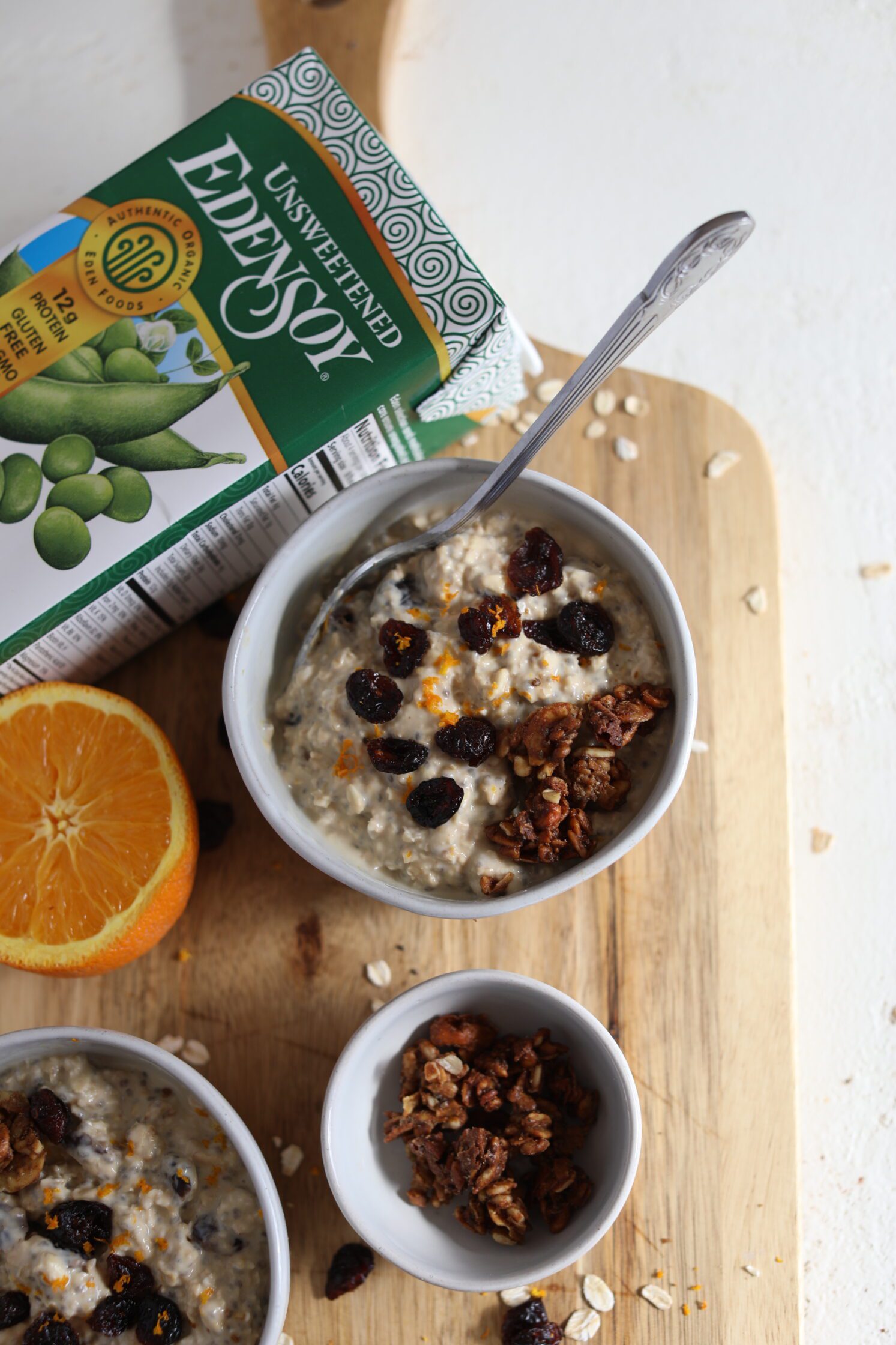 Orange Cranberry Overnight Oats served on wooden board by Flora & Vino