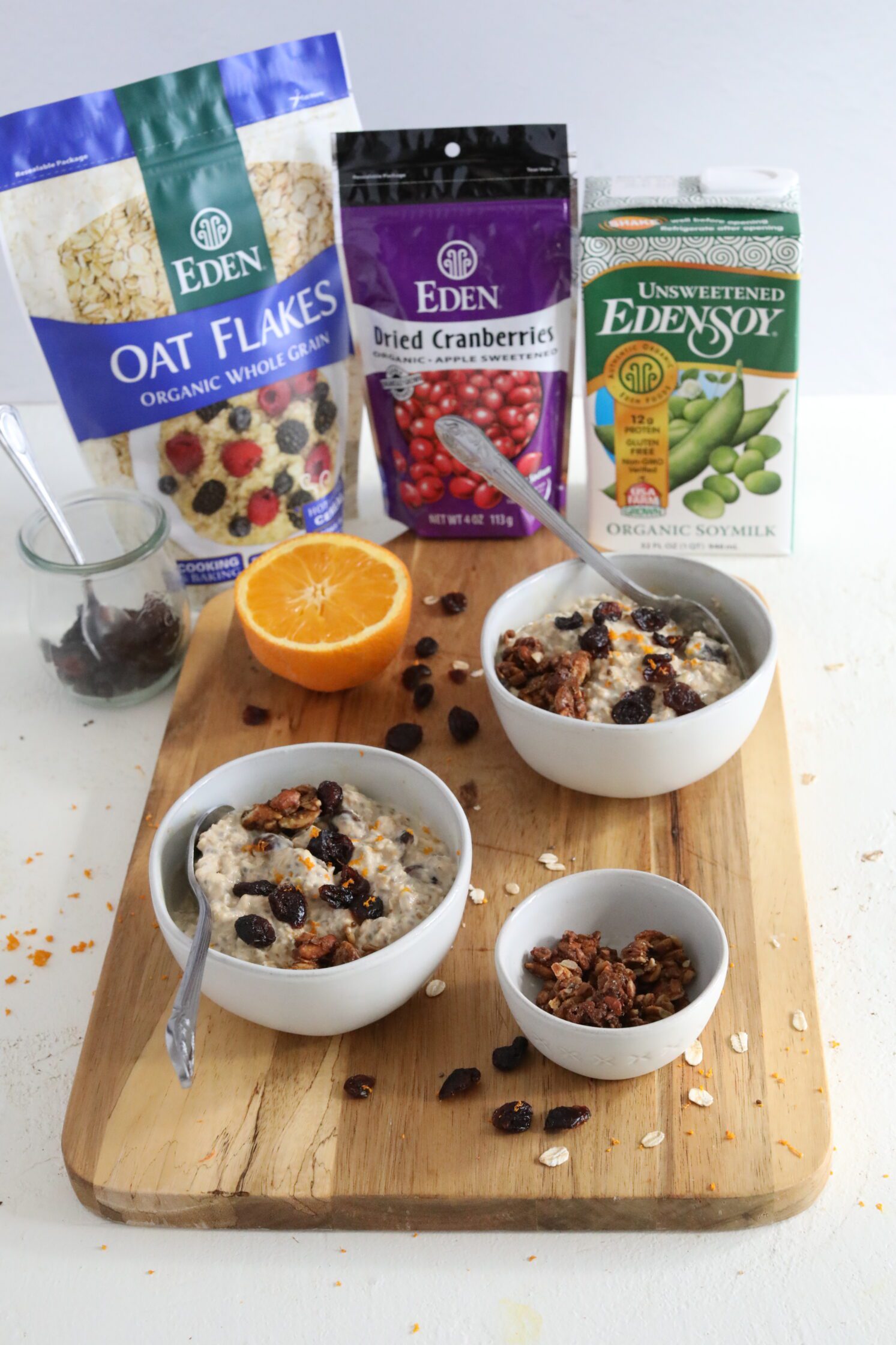 Orange Cranberry Overnight Oats served on wooden board by Flora & Vino