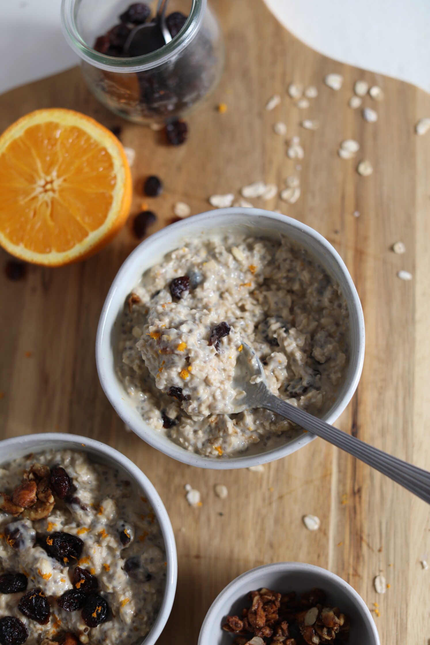 Orange Cranberry Overnight Oats served in bowls with spoon by Flora & Vino
